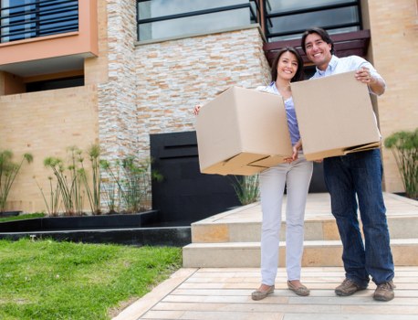 Removal staff carrying boxed items with careful lifting technique